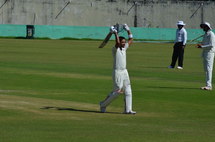 Prashant Chopra raises his bat after reaching 300
