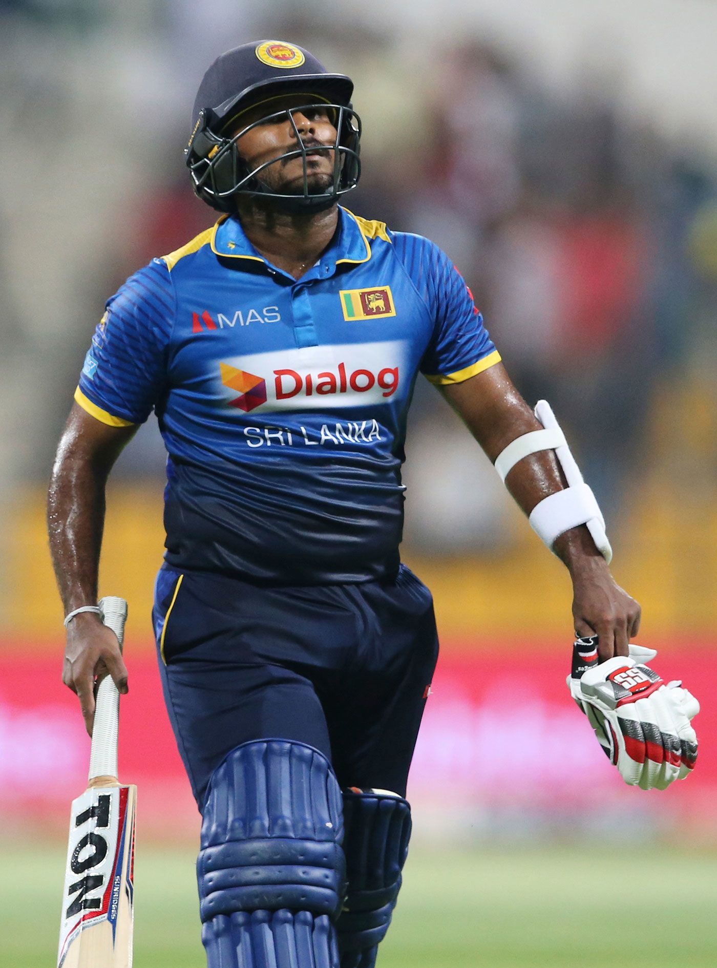 Dilshan Munaweera walks back after being dismissed