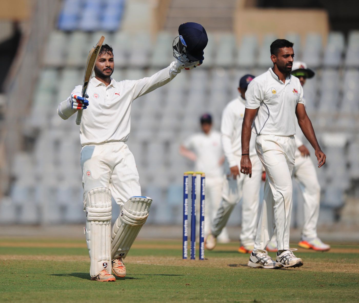 Aditya Waghmode raises his bat after reaching a hundred