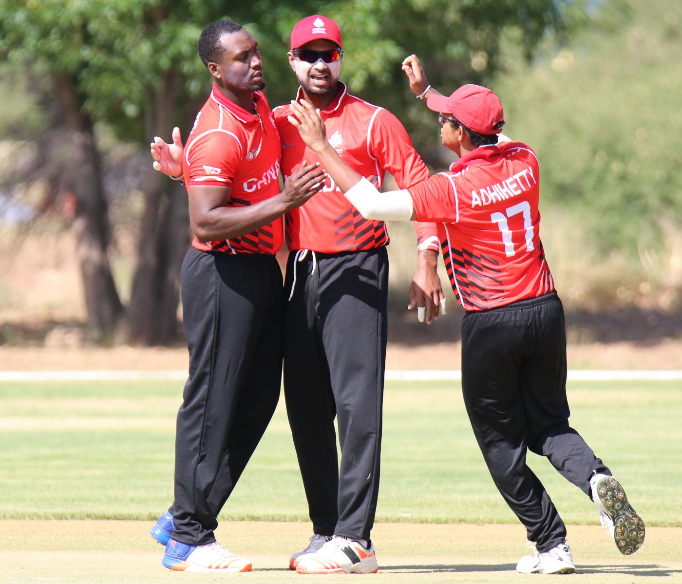 Dilon Heyliger gets hugs from Ruvindu Gunasekera and Bhavindu Adhihetty after taking his first wicket