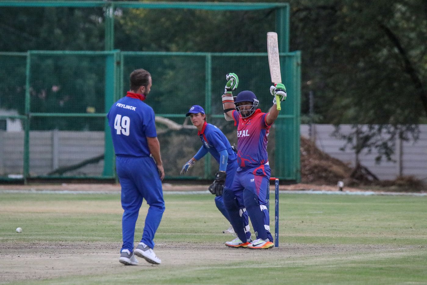 Basant Regmi raises his arms aloft after a leg-side wide clinches a one-wicket win