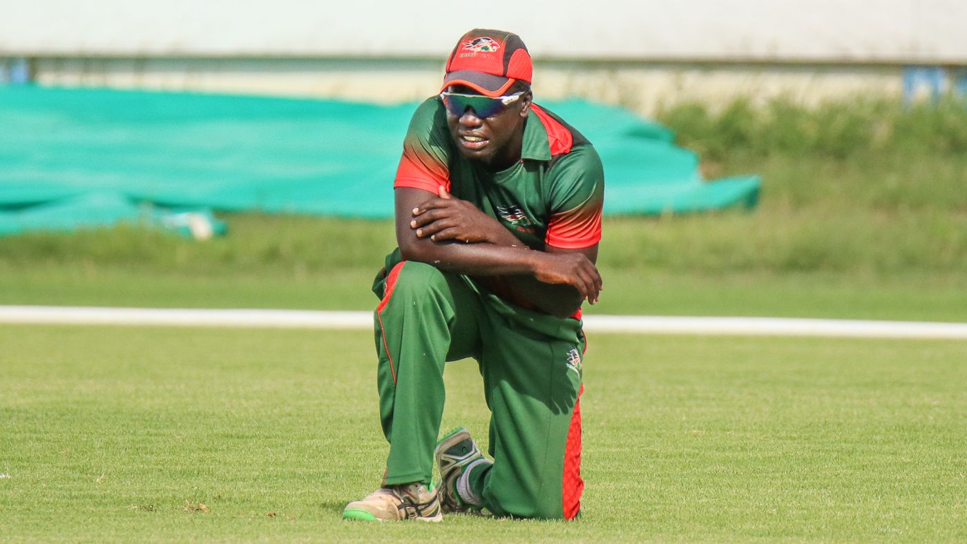 Shem Ngoche kneels alone on the outfield after misfielding the final ball of the match