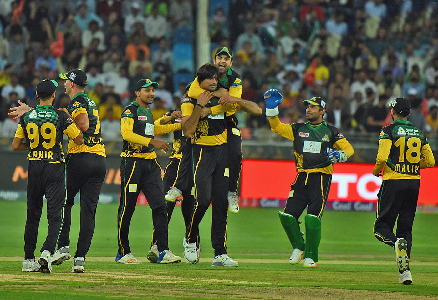 Mohammad Irfan is mobbed by his team-mates upon picking up a wicket