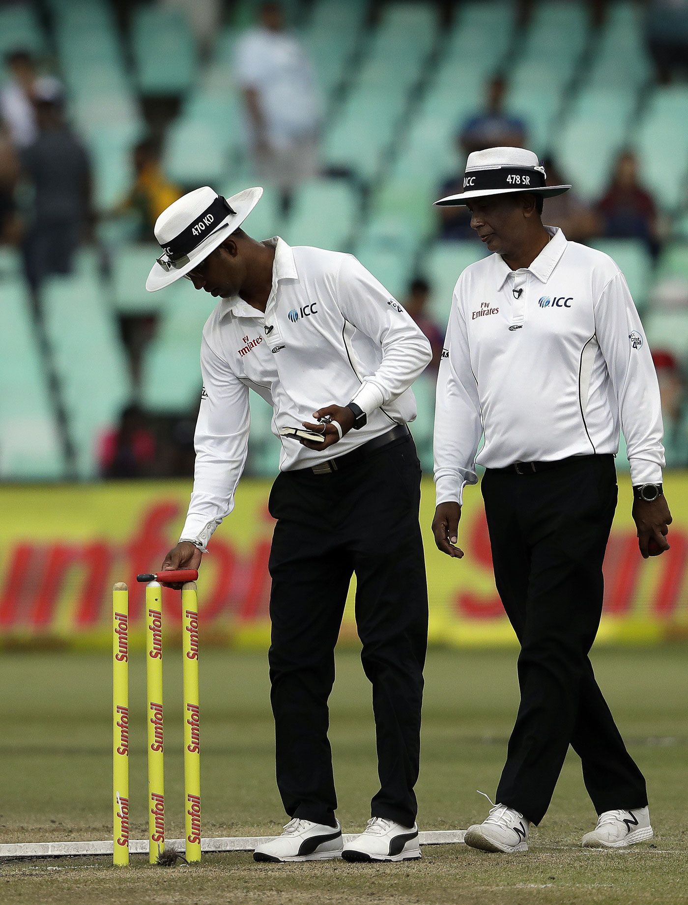 Umpire Kumar Dharmasena checks the reading on a light meter