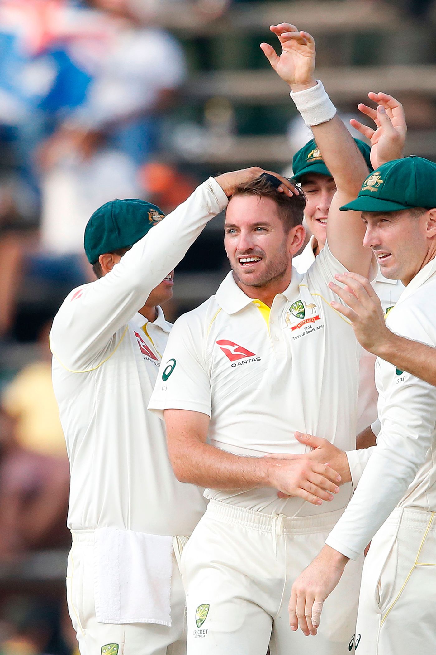 Chadd Sayers is mobbed by his team-mates after picking up his first Test wicket