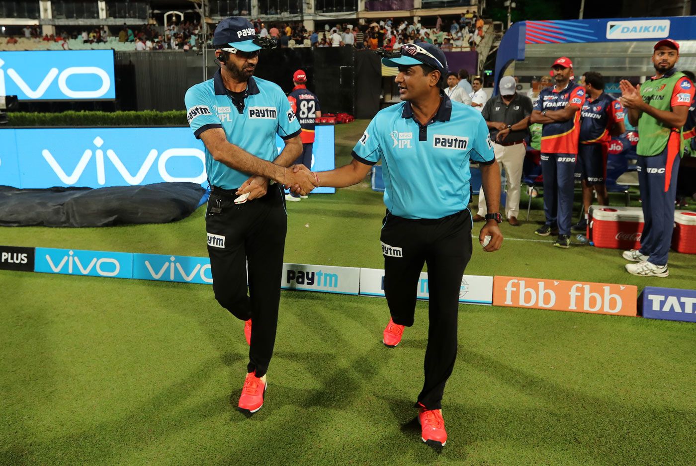 Umpires Anil Chaudhary and Nand Kishore walk out