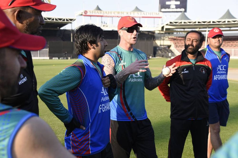Fielding coach John Mooney talks to the team