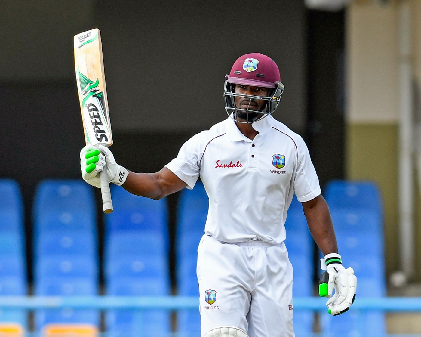 Devon Smith raises his bat after getting to his fifty