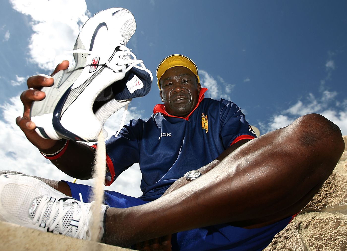 Gladstone Small pours out sand from his shoes during a beach cricket game in Perth