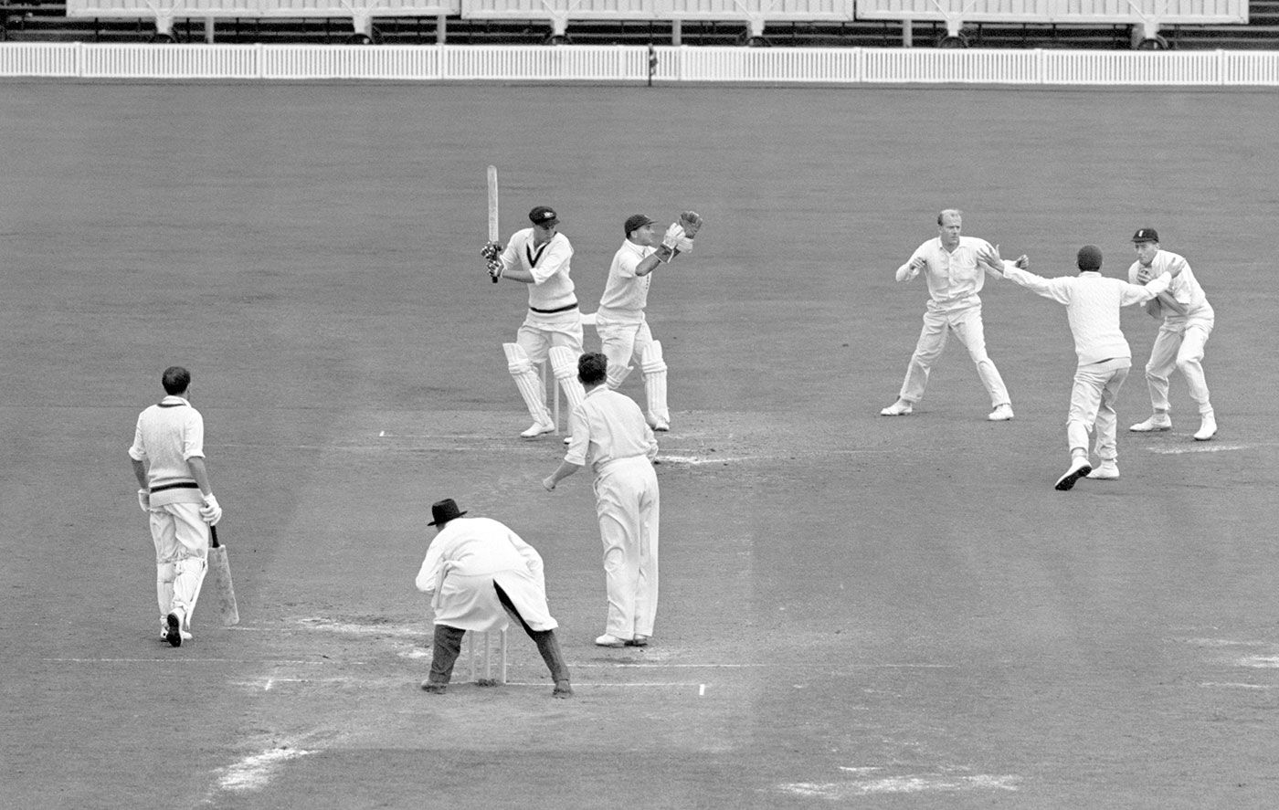 Alan Oakman (right) takes a catch off Jim Laker