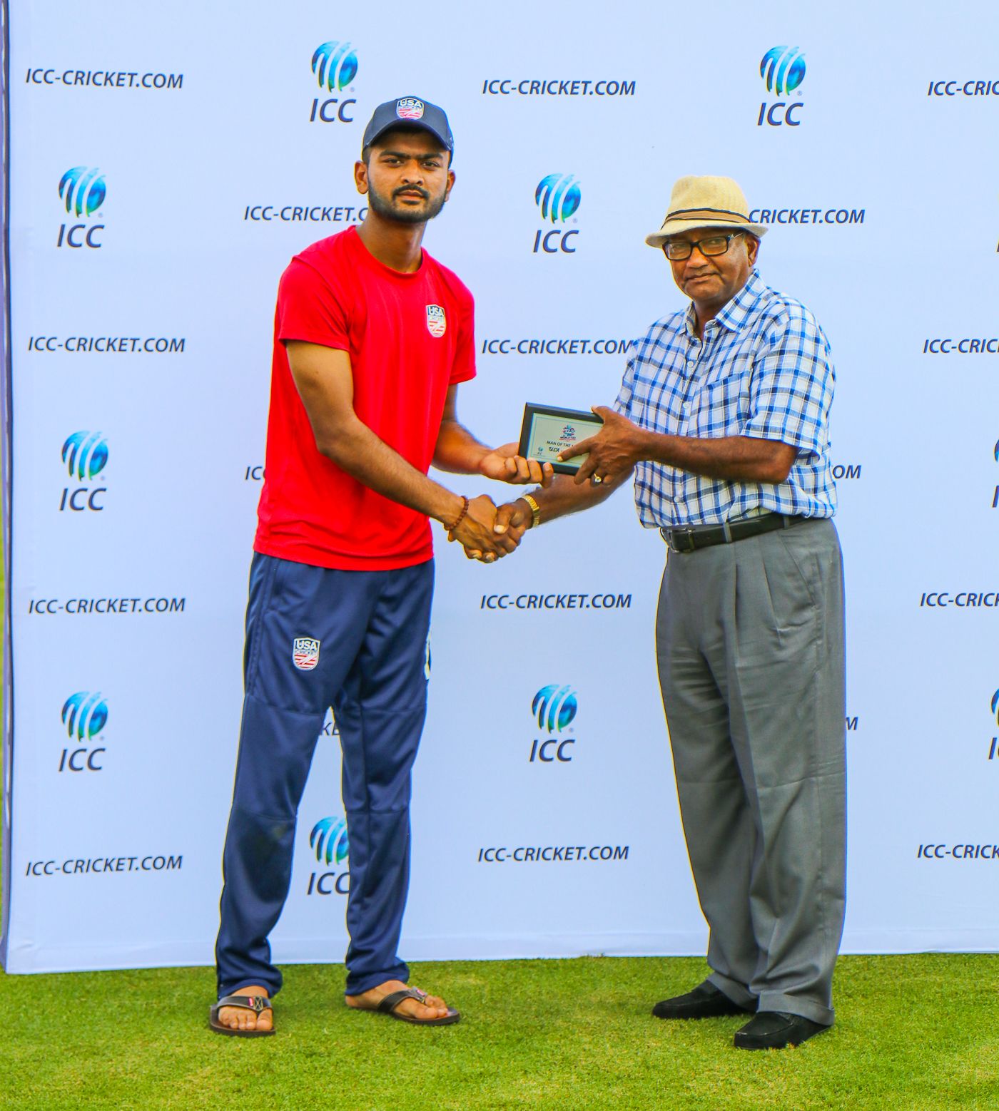 Monank Patel accepts the Man of the Match award from former West Indies player Alvin Kallichharan