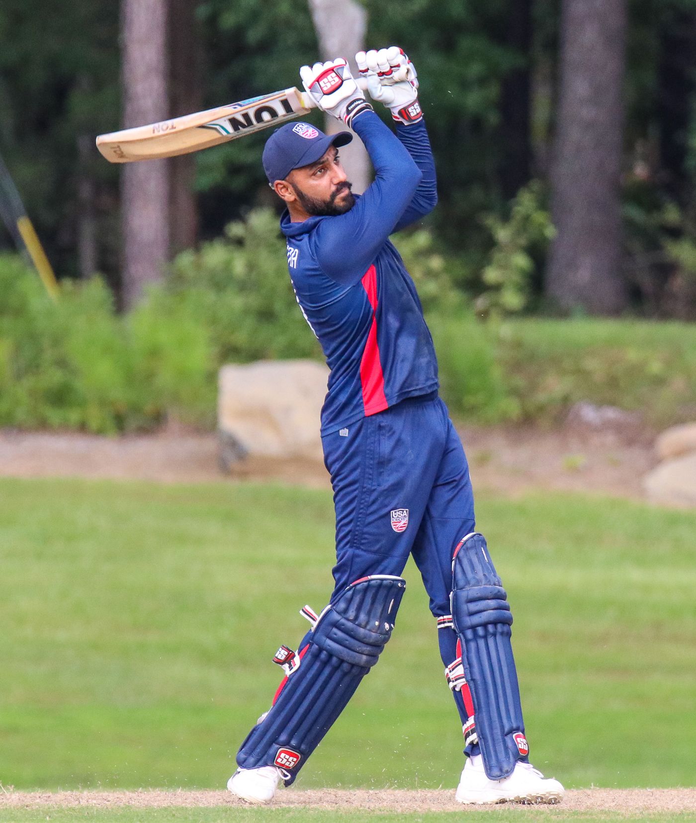 Jaskaran Malhotra plays a lofted drive straight down the ground for six