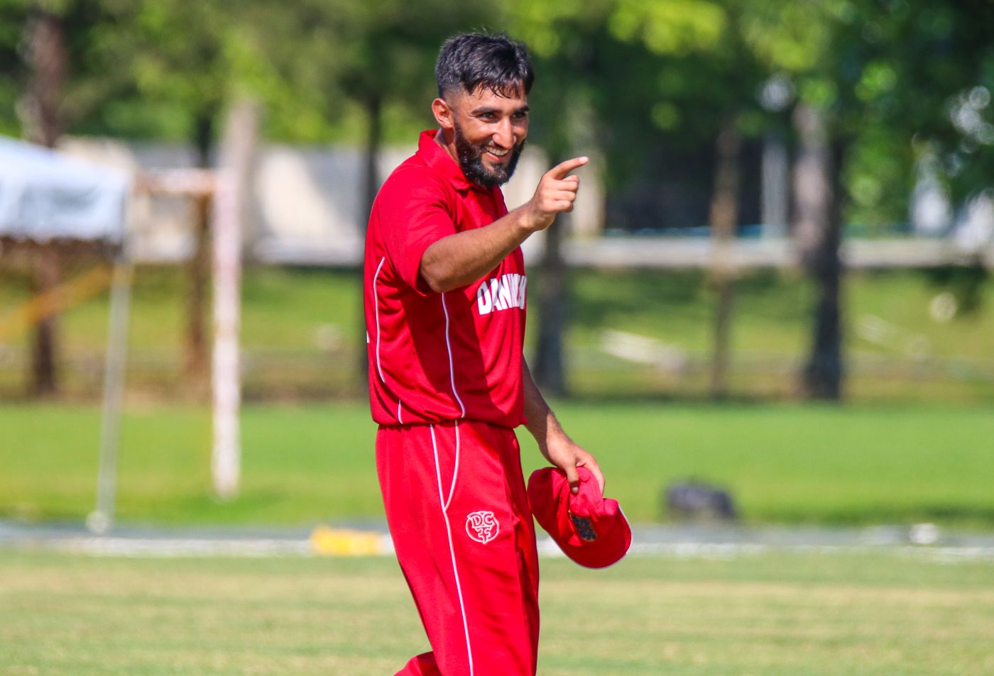 Denmark captain Hamid Shah points victoriously toward the coaching staff after the win