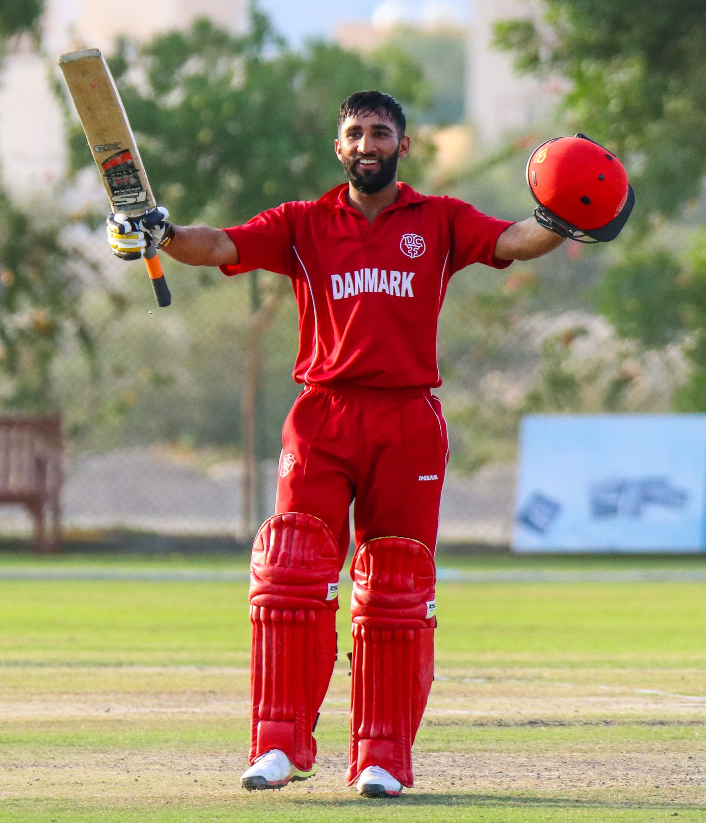 Captain Hamid Shah raises his bat after reaching a century