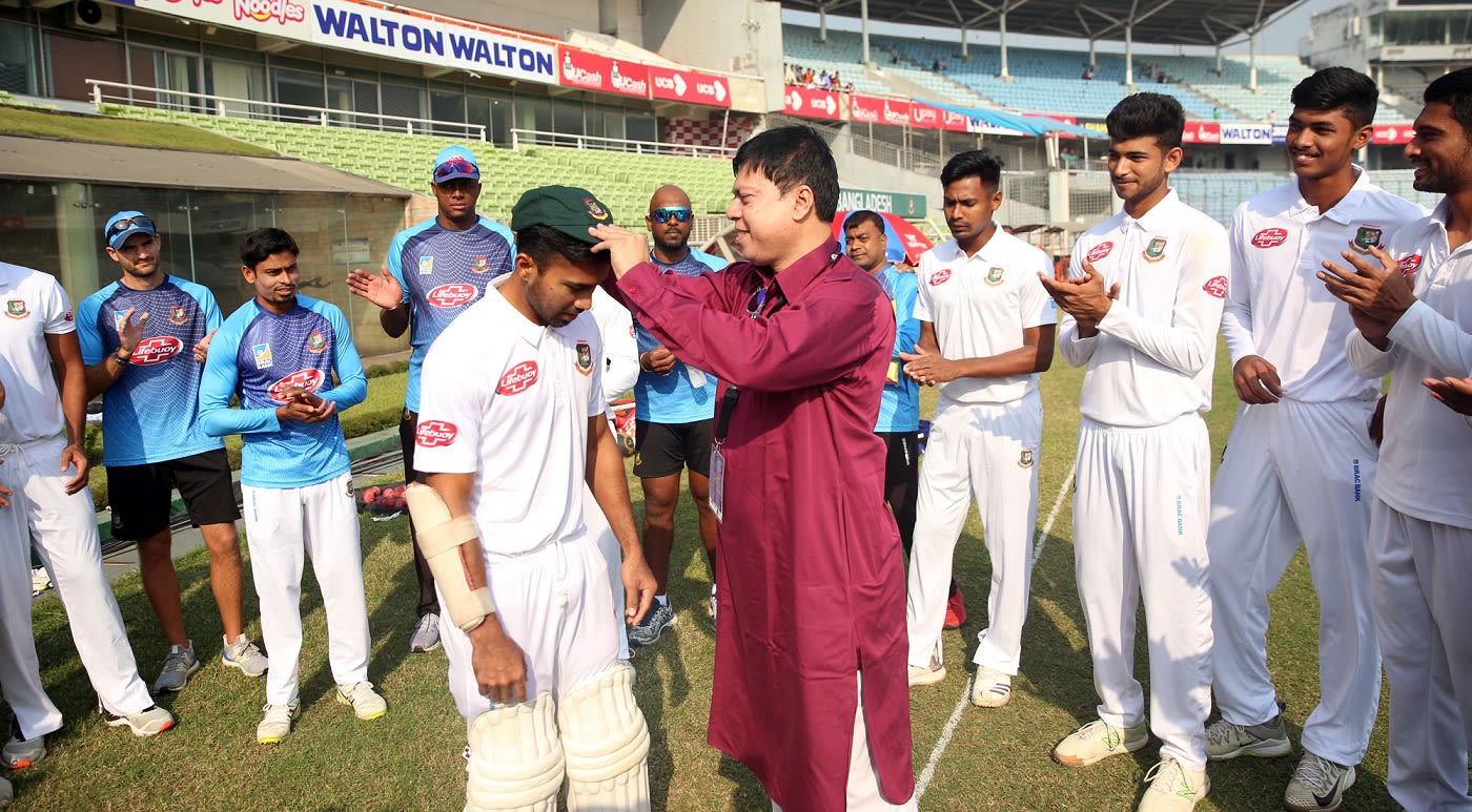 Chief selector Minhajul Abedin presents debutant Shadman Islam with a cap