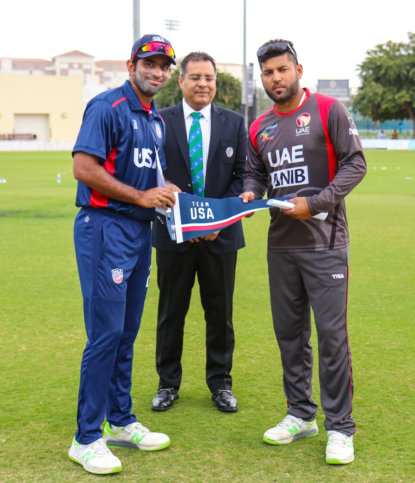 USA captain Saurabh Netravalkar presents a Team USA flag at the toss for USA's maiden T20I