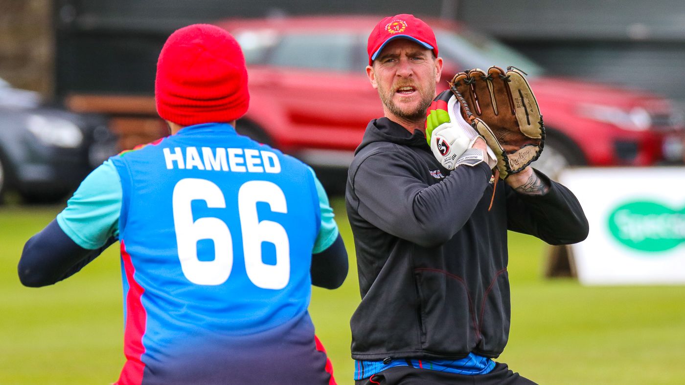 Fielding coach John Mooney demonstrates catching technique during Afghanistan training