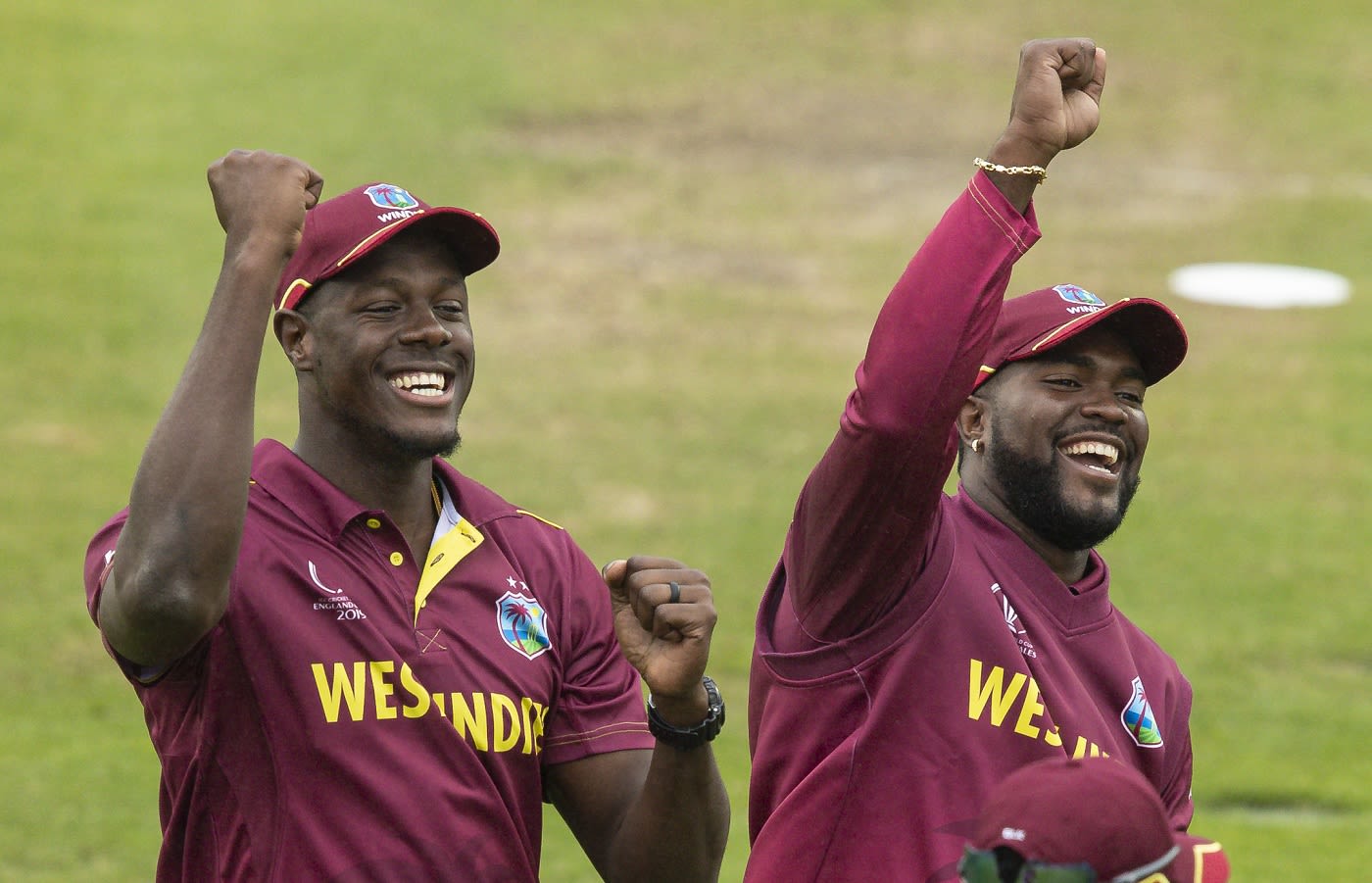 Carlos Brathwaite and Ashley Nurse sing with the crowd during a rain break