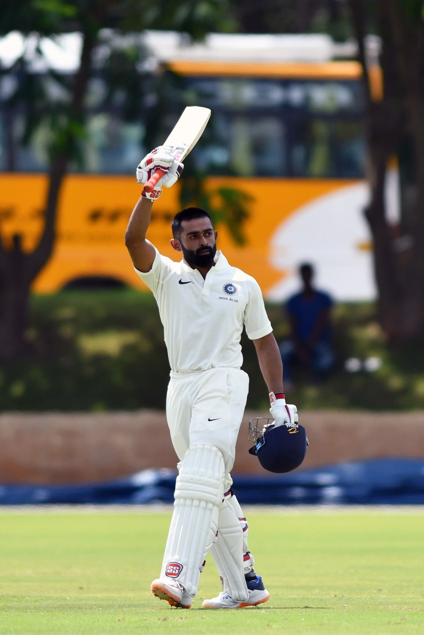 Ankit Bawne raises his bat after reaching a hundred