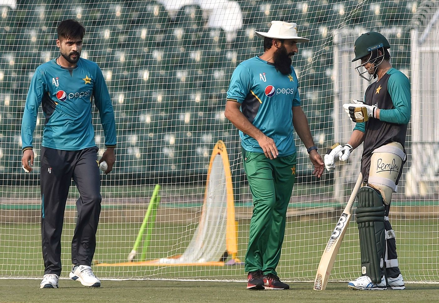 Coach Misbah-ul-Haq chats with Ahmed Shehzad during a training session