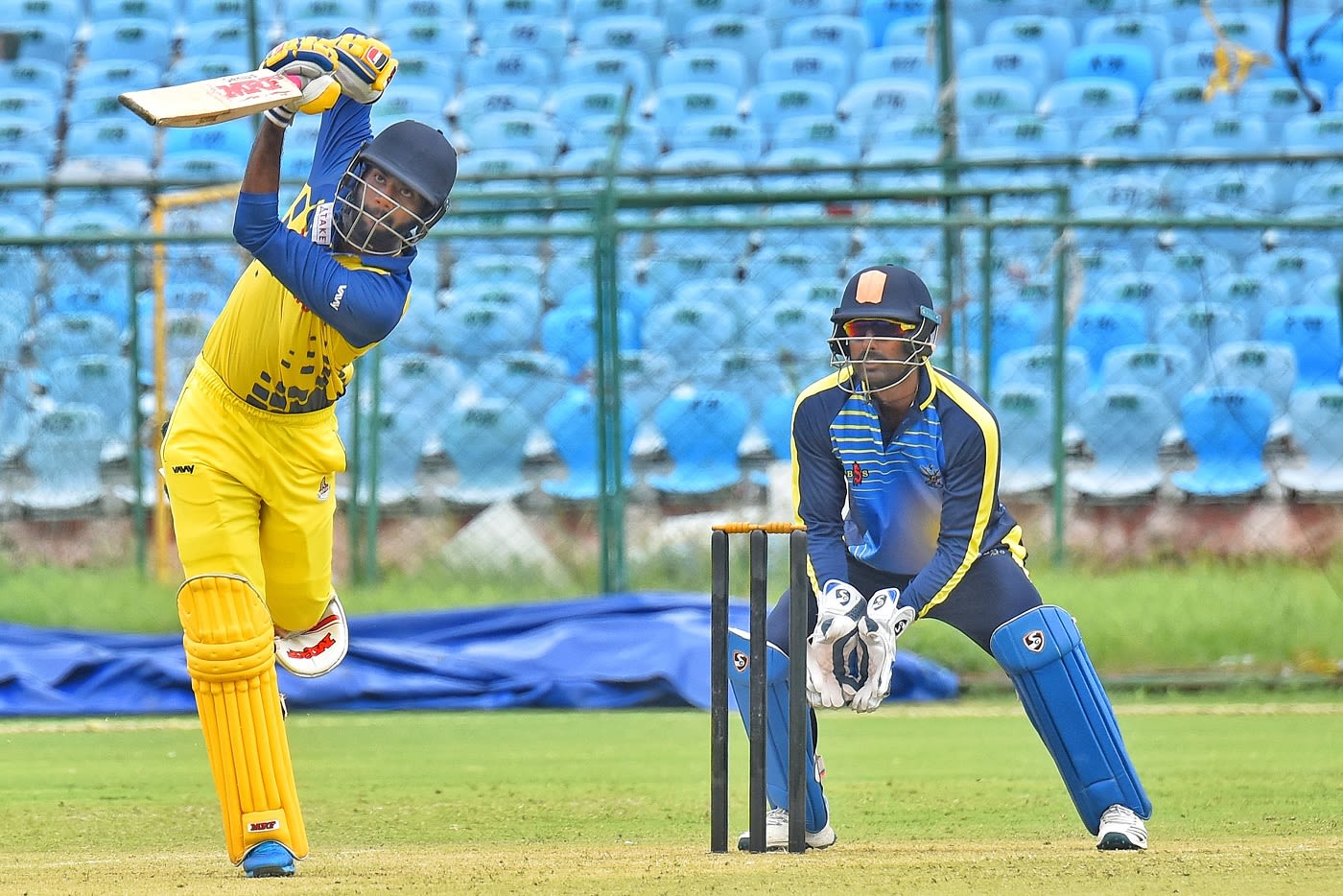 C Hari Nishaanth chips one down the ground as Nakul Verma looks on