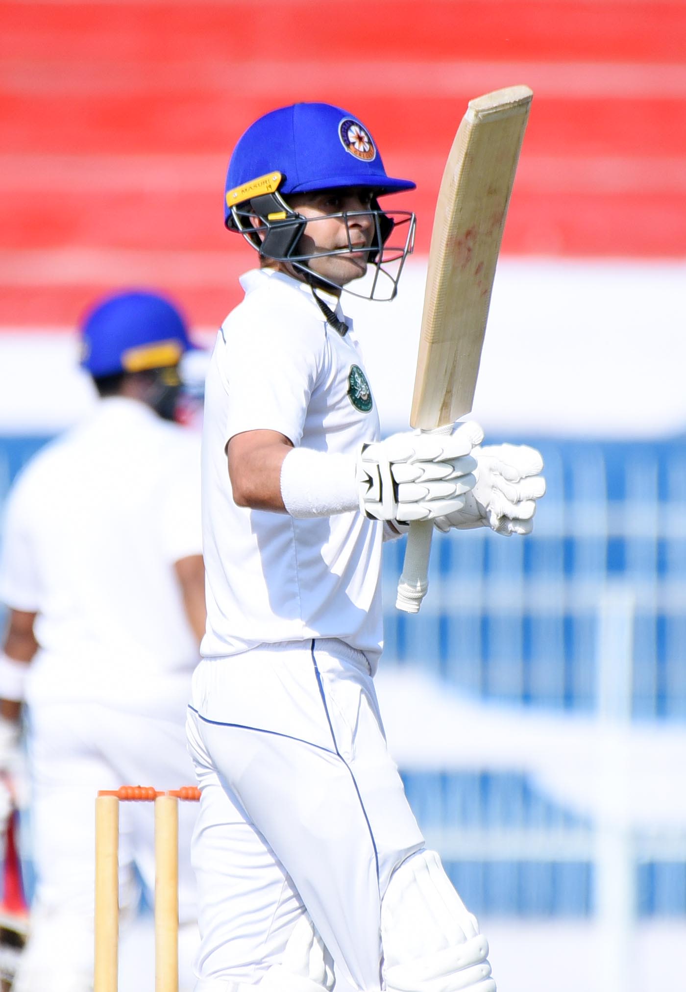 Ahmed Shehzad raises his bat after reaching his half-century