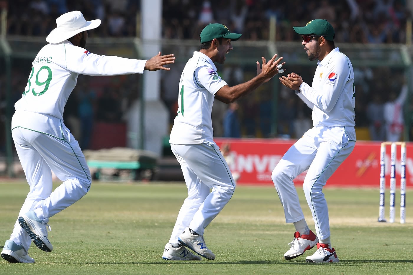 Asad Shafiq and Babar Azam celebrate the fall of a wicket in the slips