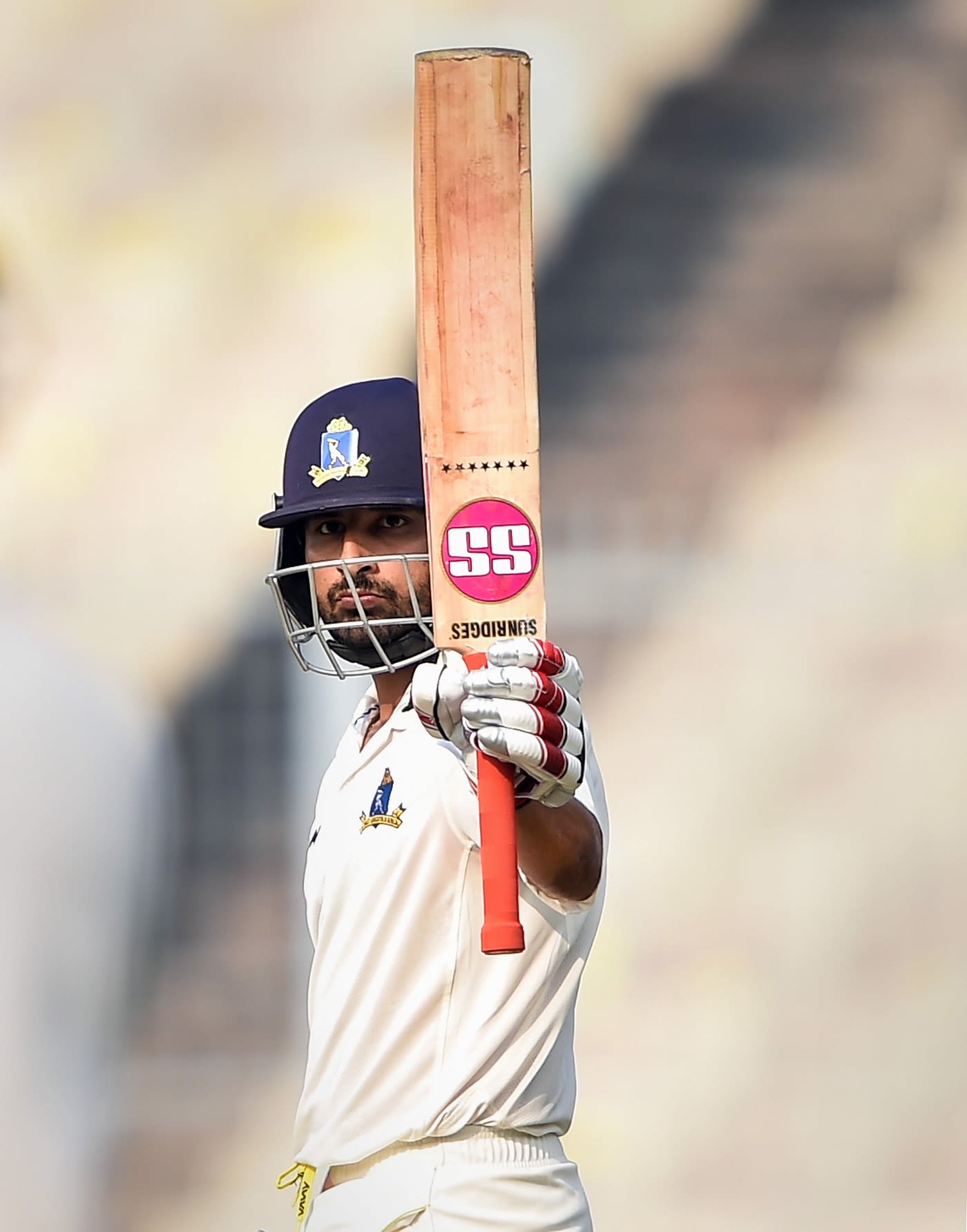 Shreevats Goswami raises his bat after reaching a hundred
