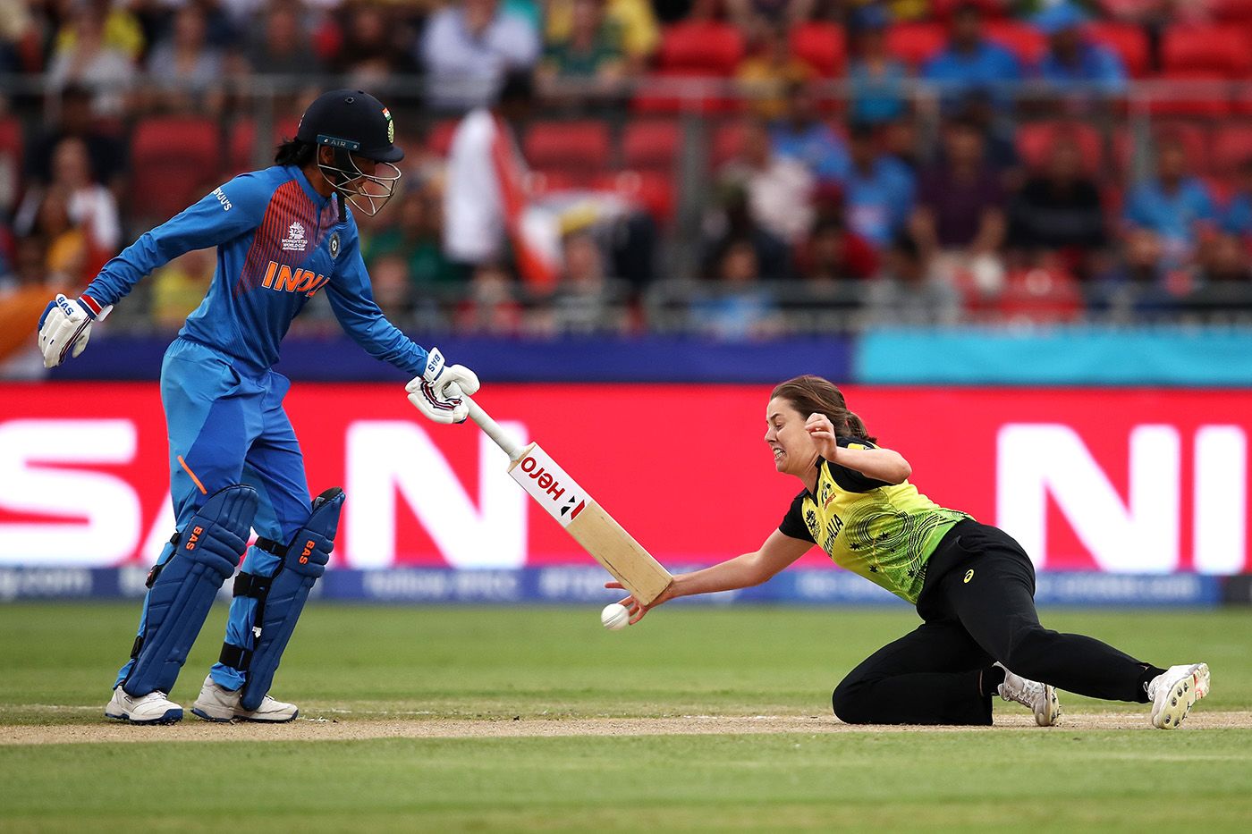 Molly Strano attempts to stop the ball as Smriti Mandhana comes in the way