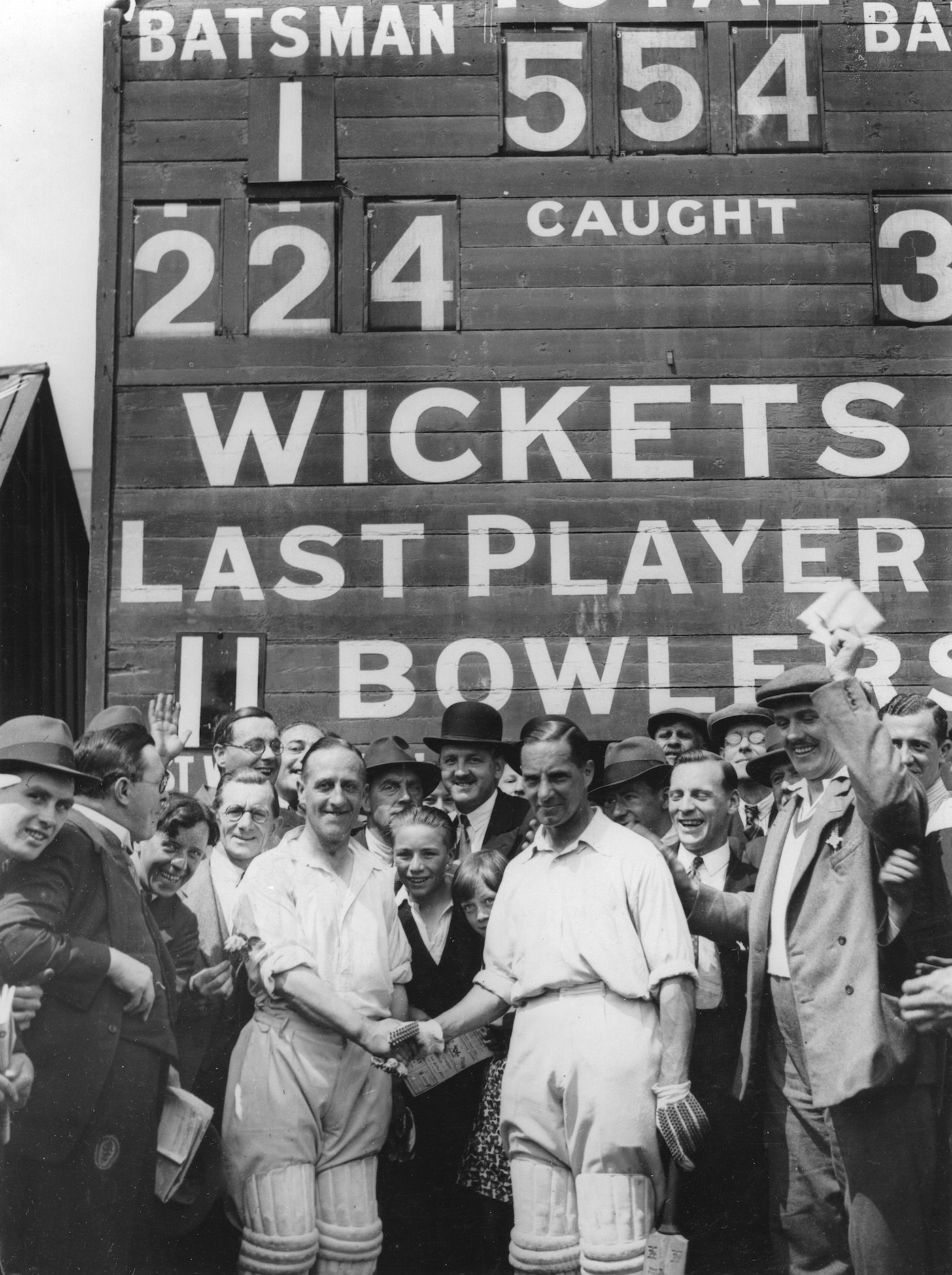 Crowds surround the scorebox just before Percy Holmes and Herbert Sutcliffe's 555 first-wicket stand