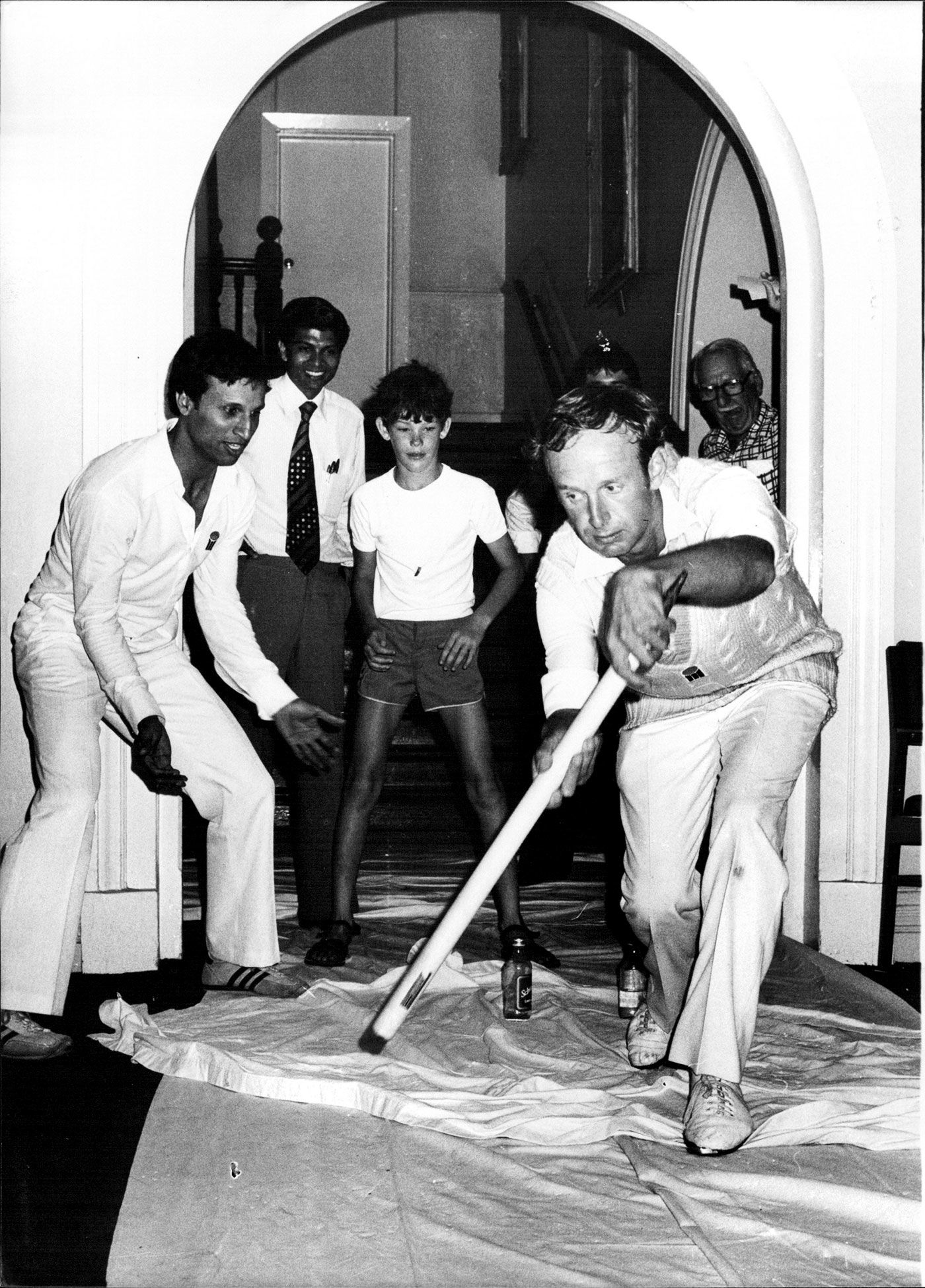 Derek Underwood bats while Asif Iqbal fields at slip and a young James Packer keeps wicket in a game of corridor cricket during a rain delay