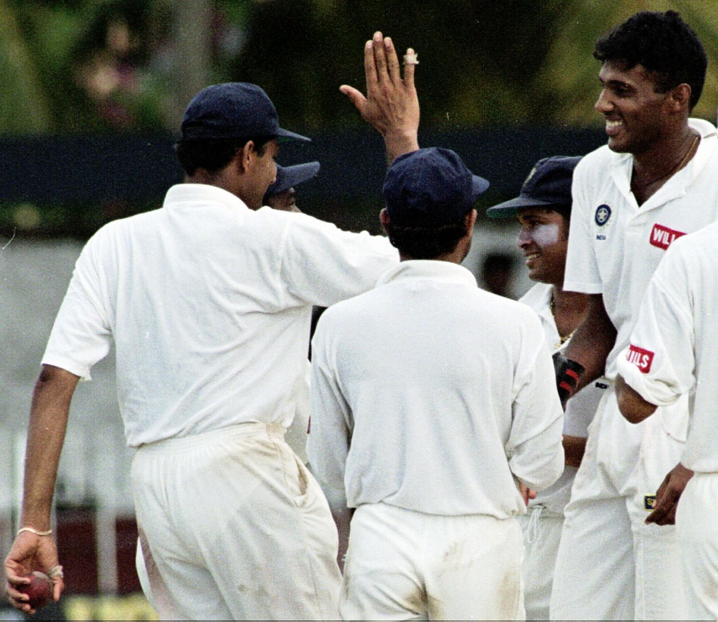 Abey Kuruvilla is congratulated by his team-mates after taking a wicket