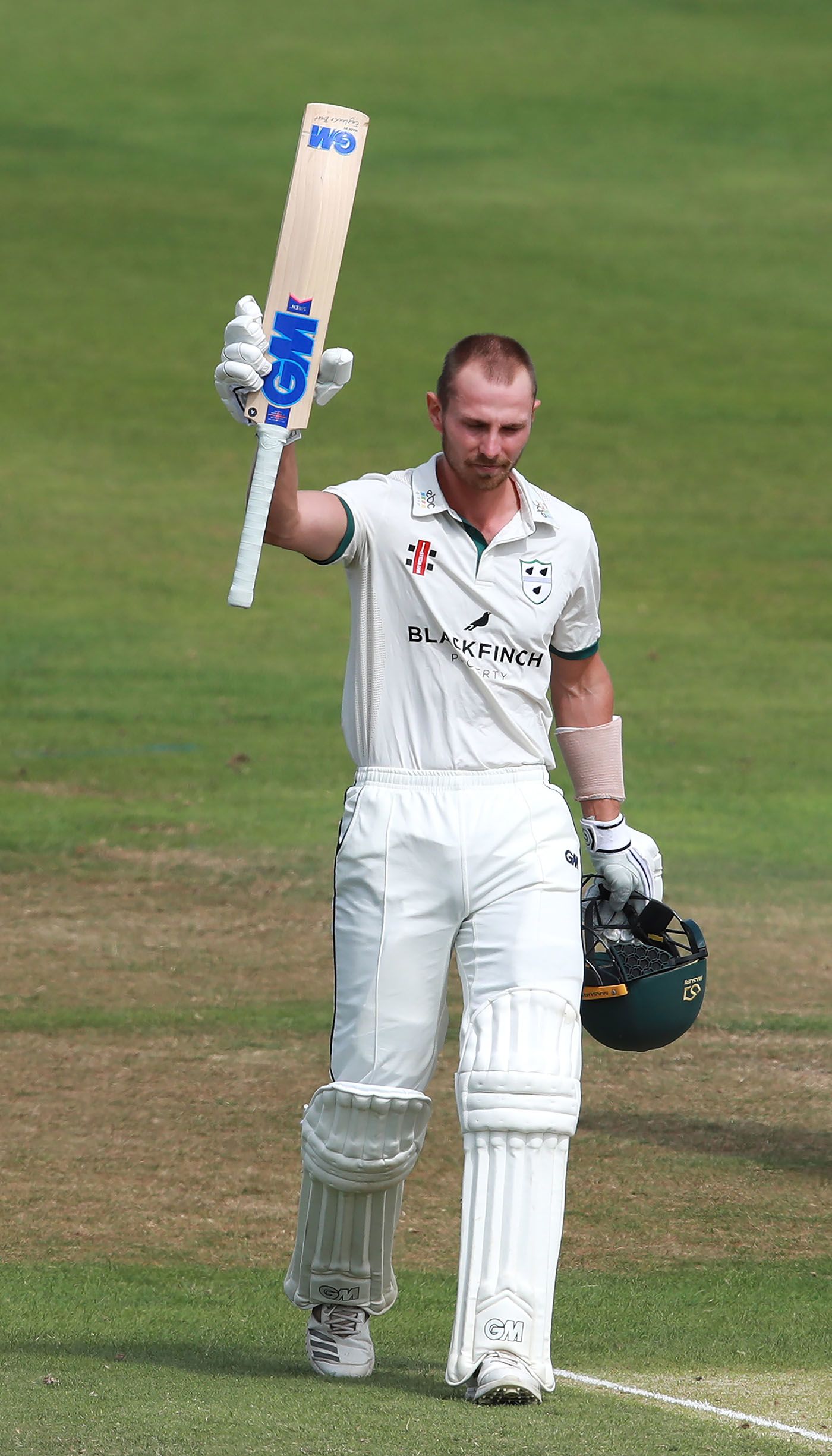 Tom Fell raises his bat for his hundred
