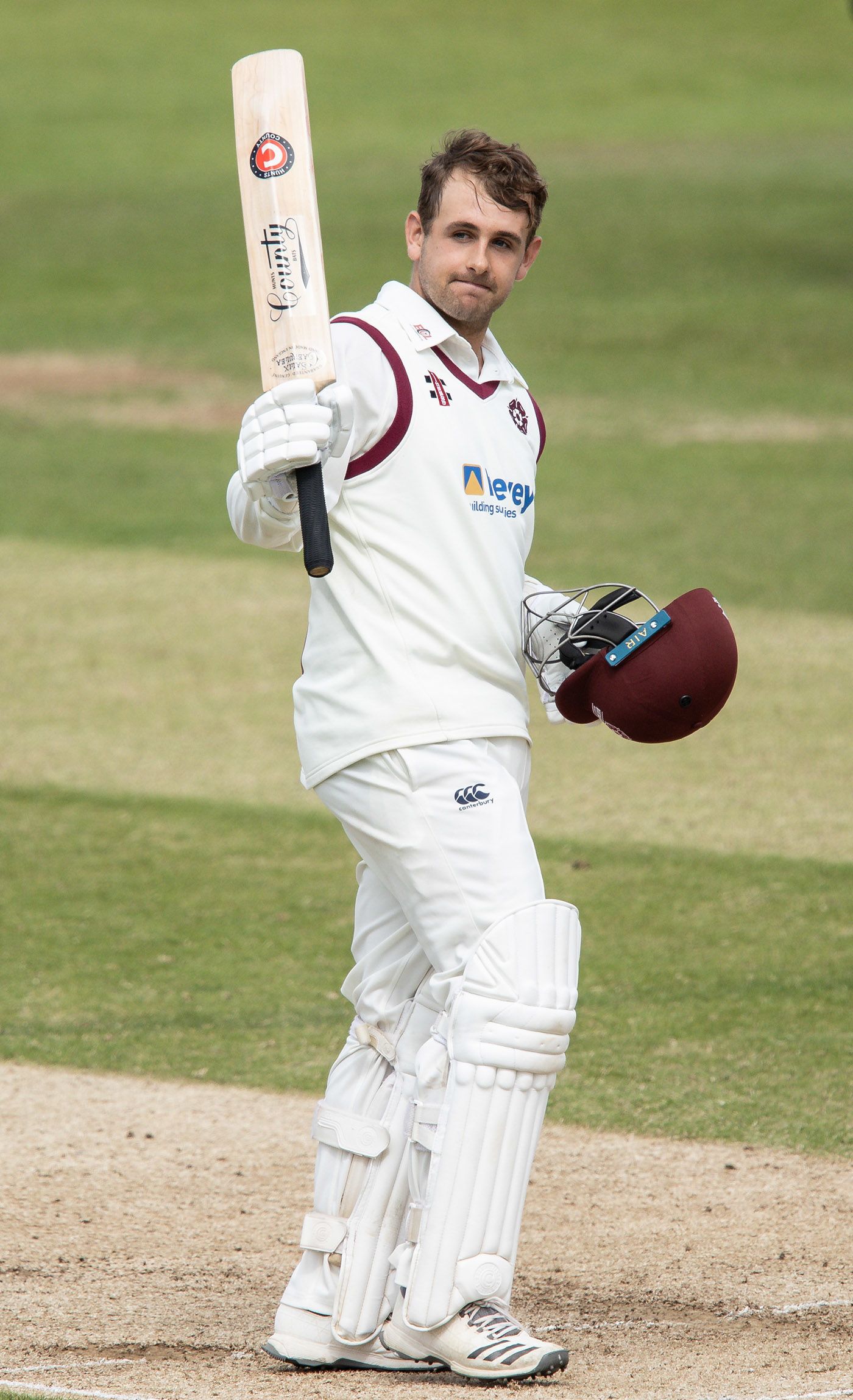 Charlie Thurston acknowledges the applause from his team-mates on reaching his century 