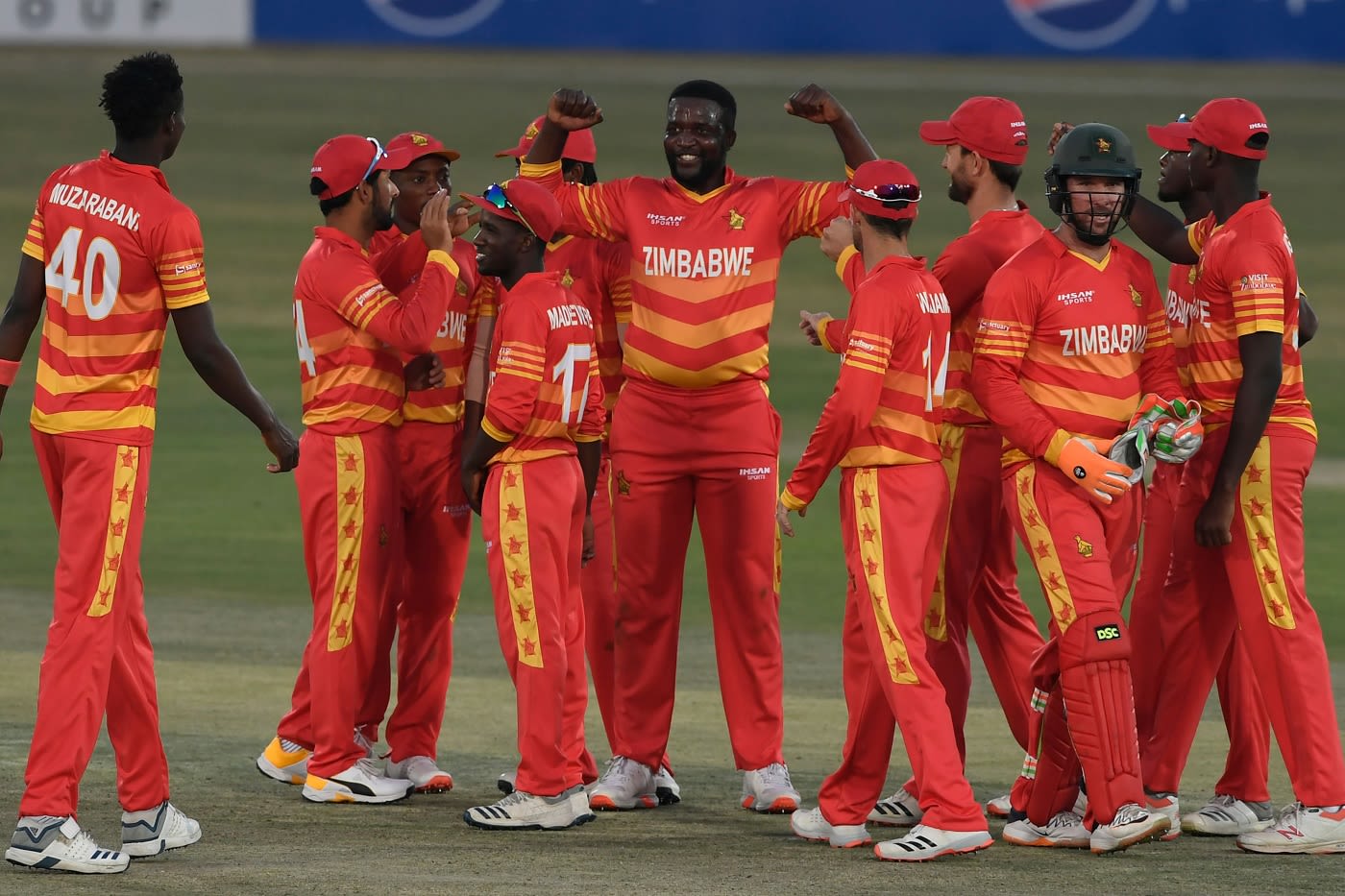 Tendai Chisoro celebrates with team-mates after dismissing Abid Ali