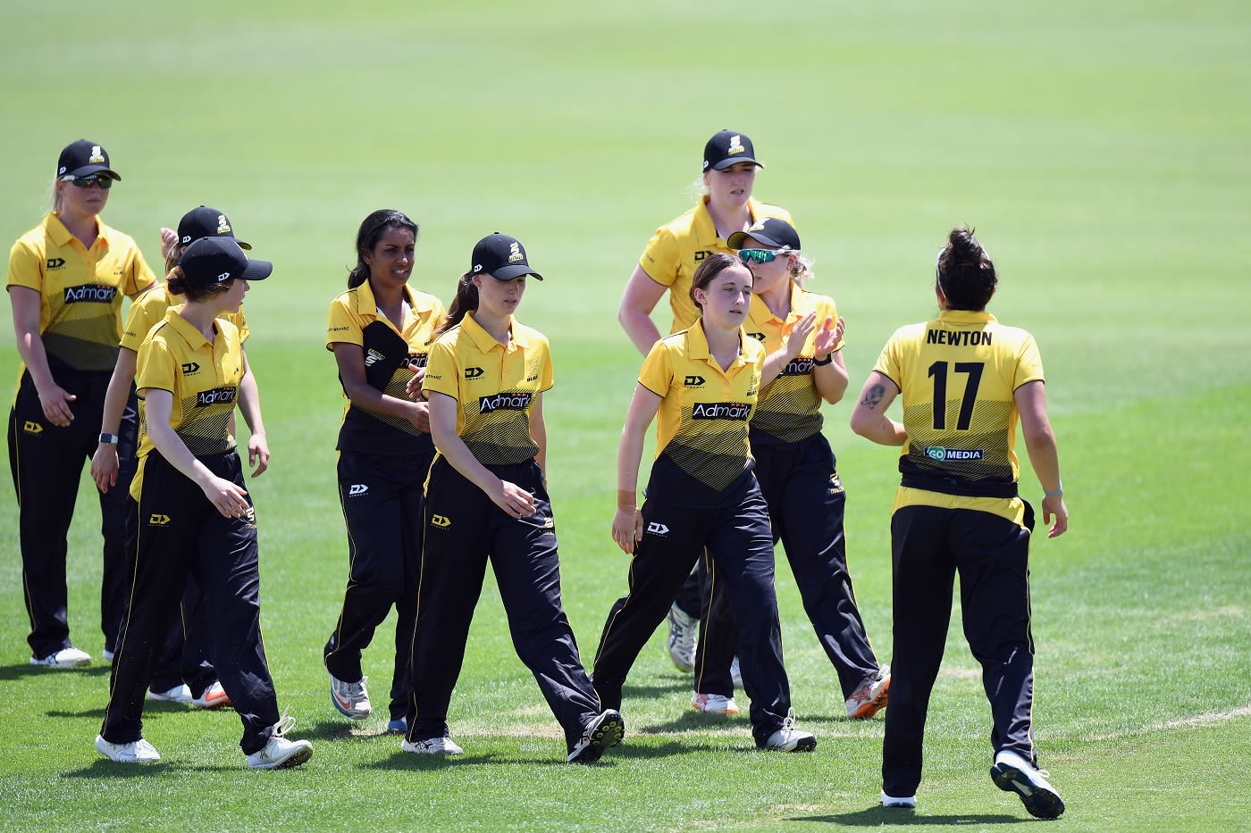 Kate Chandler is congratulated by her team-mates after completing her five-for