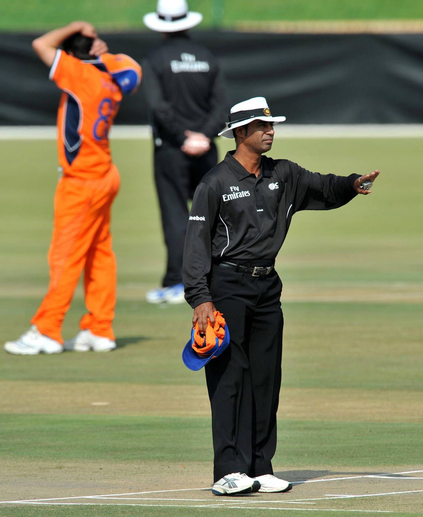 Umpire Enamul Haque Moni signals a four