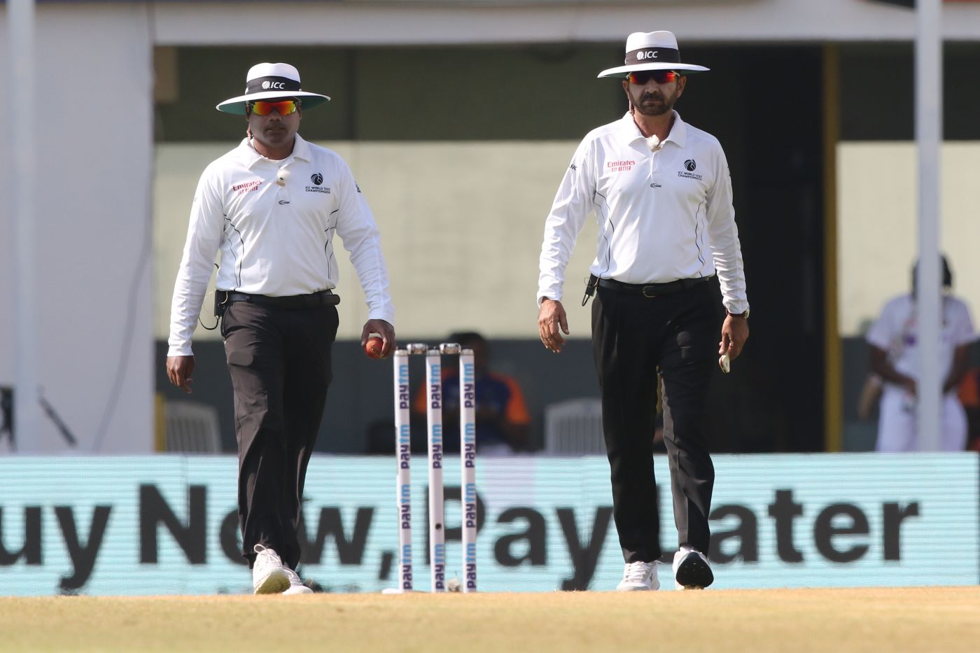 Umpires Nitin Menon and Anil Chaudhary walk out for day four