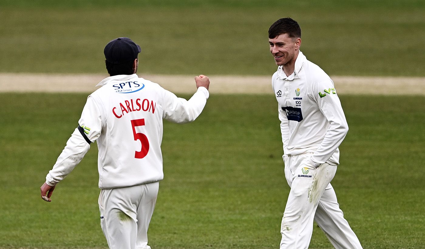 Callum Taylor keeps his hands in his pockets while celebrating a wicket with fielder Kiran Carlson