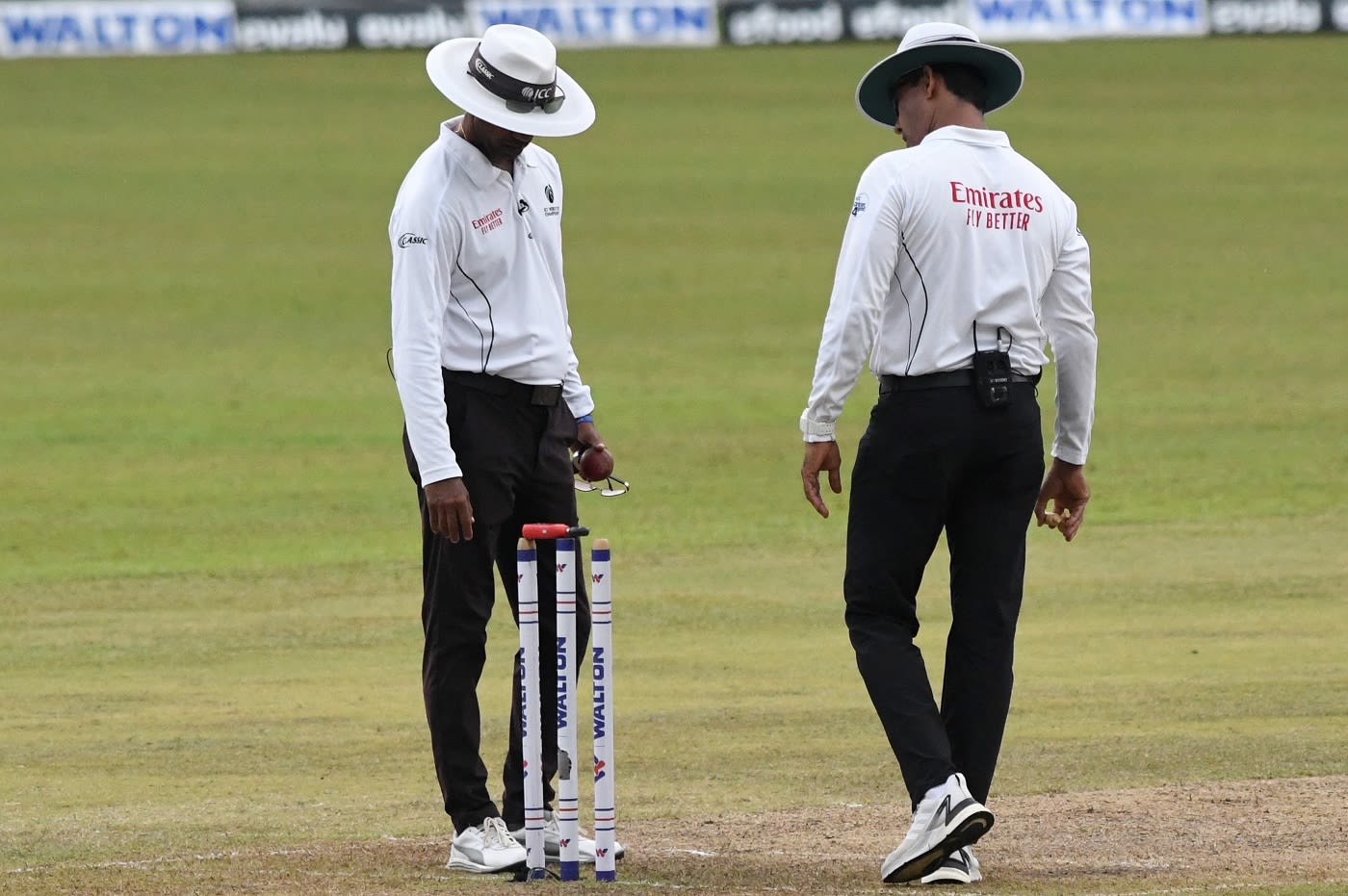 Umpires Kumar Dharmasena and Ruchira Palliyaguruge check the light on a cloudy evening