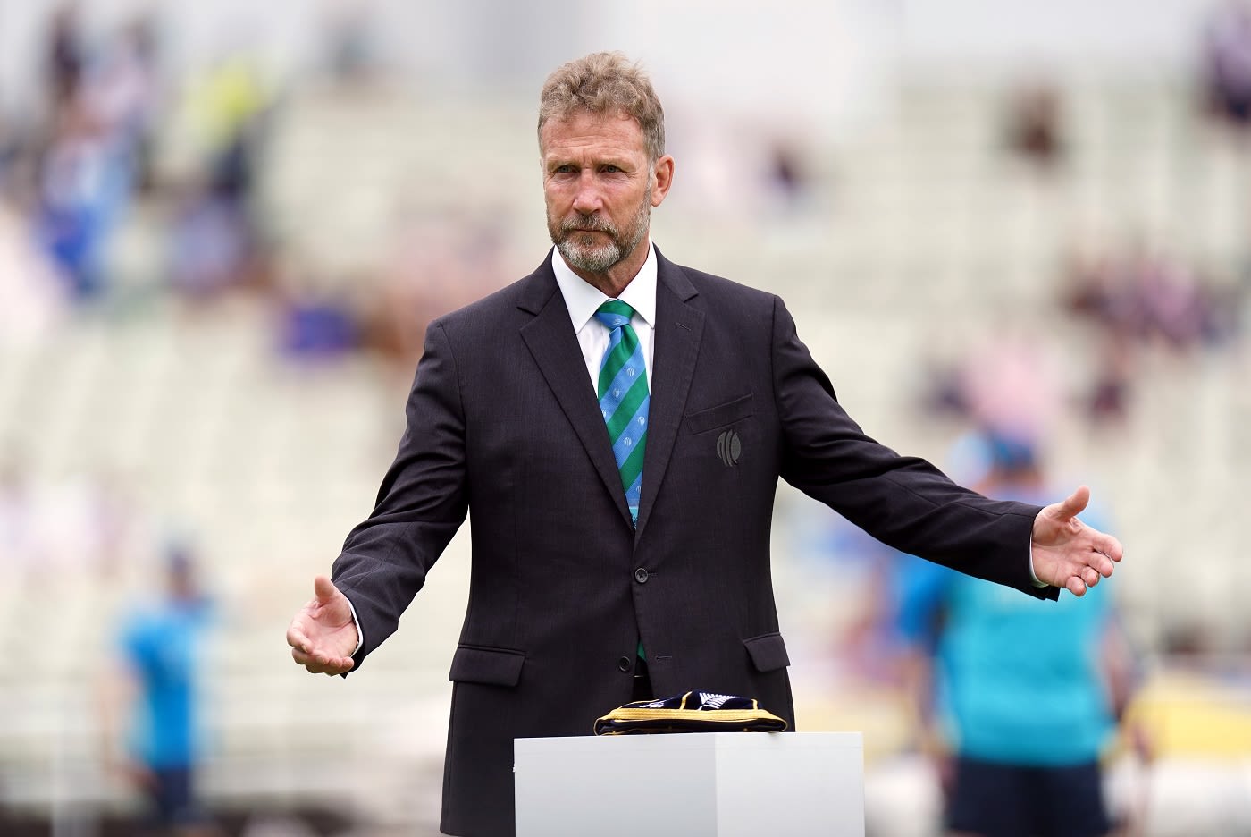 Match referee Chris Broad gestures during the coin toss