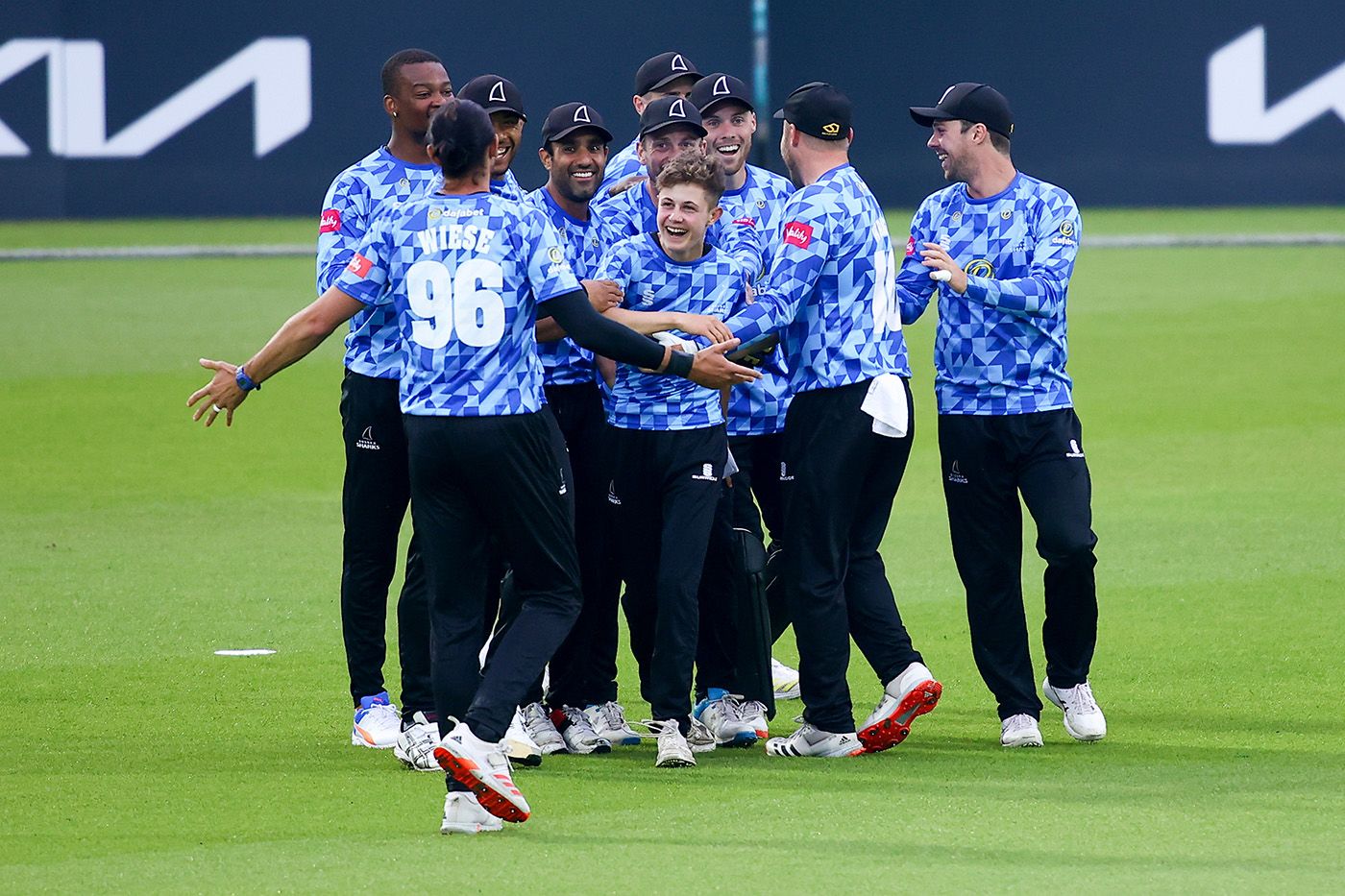 Archie Lenham is mobbed by his team-mates after taking a catch