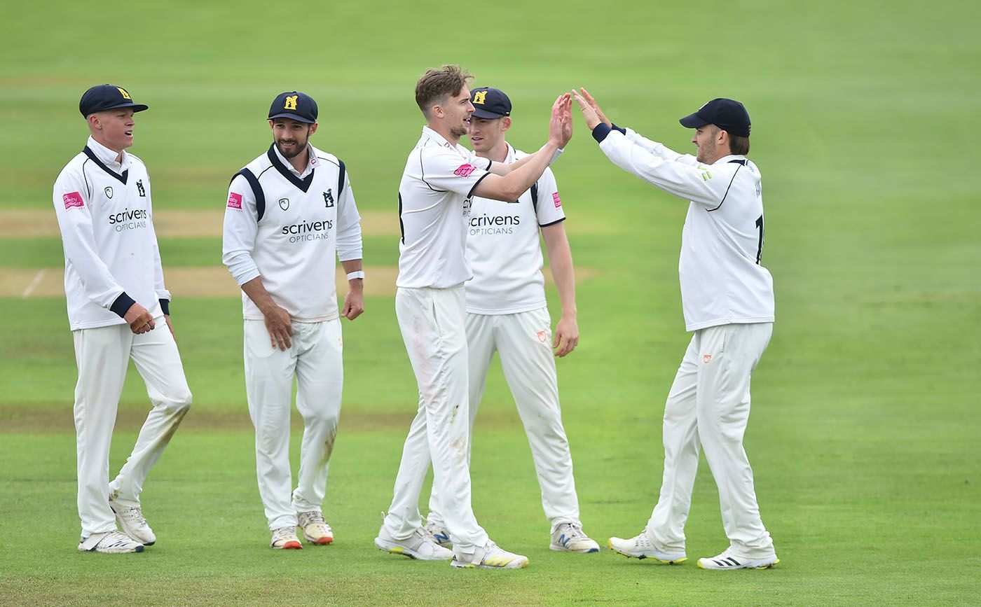 Craig Miles celebrates a wicket with his team-mates