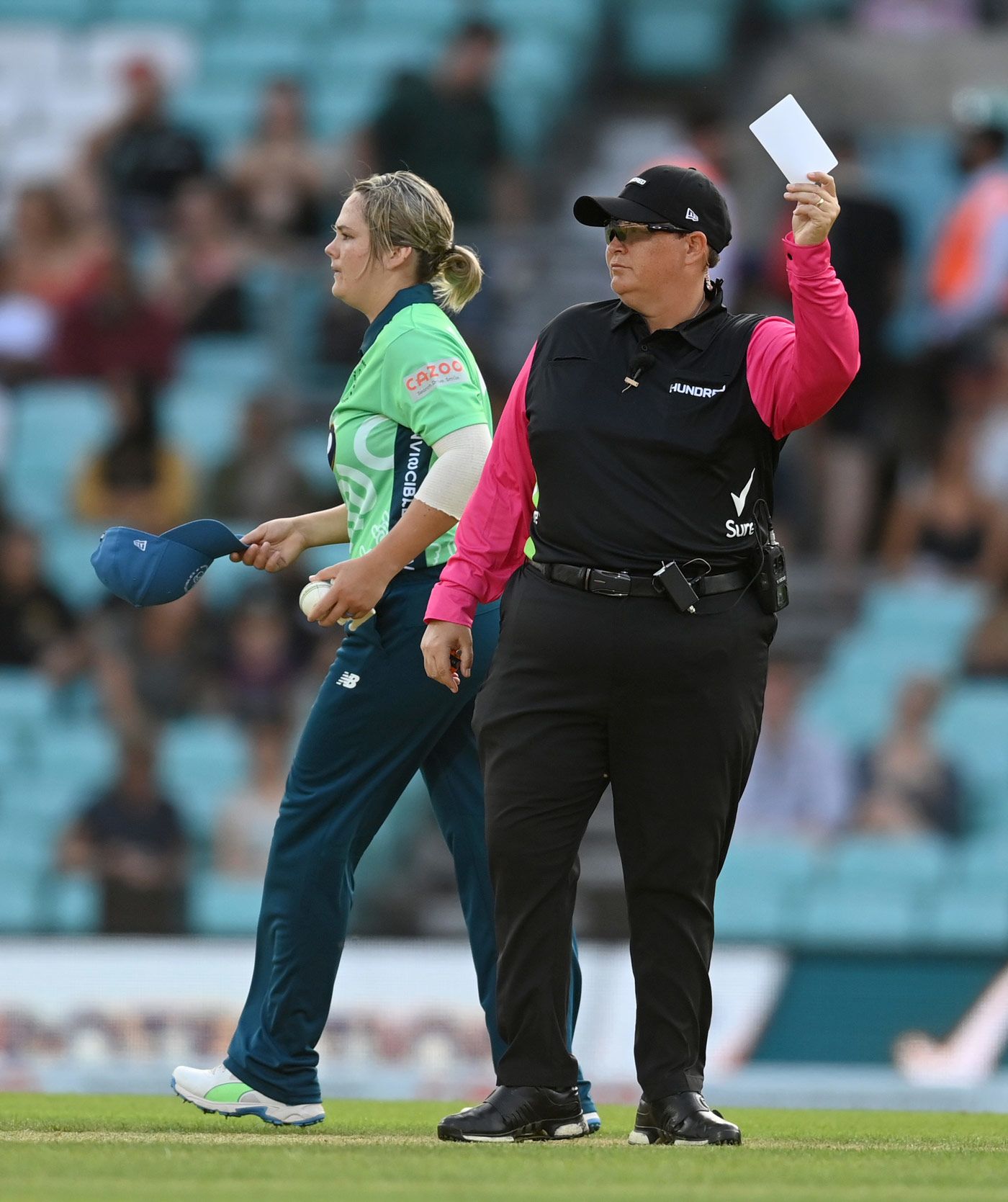 Umpire Sue Redfern makes a signal with the white card