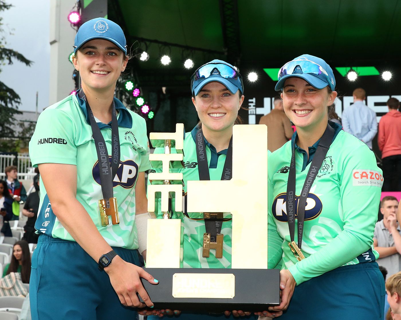 Grace Gibbs, Mady Villiers and Alice Capsey hold the Hundred trophy