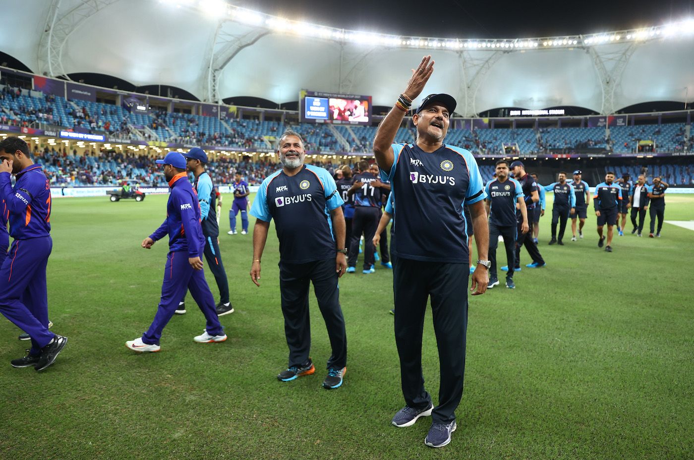 Ravi Shastri gestures to the crowd as Bharat Arun looks on