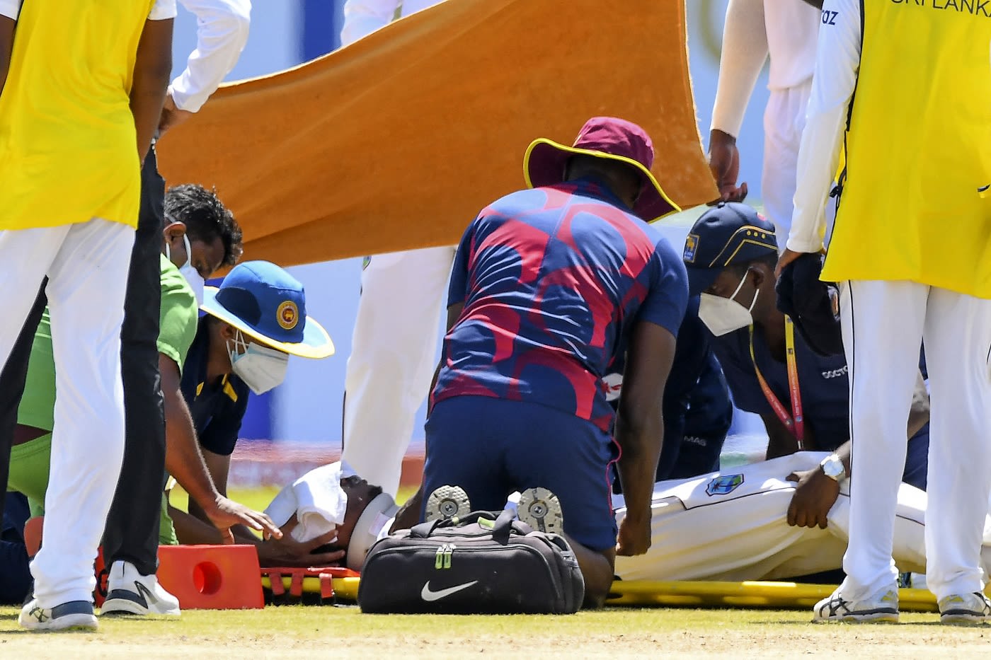 Medical teams from both Sri Lanka and West Indies attend to Jeremy Solozano, with a towel covering his forehead