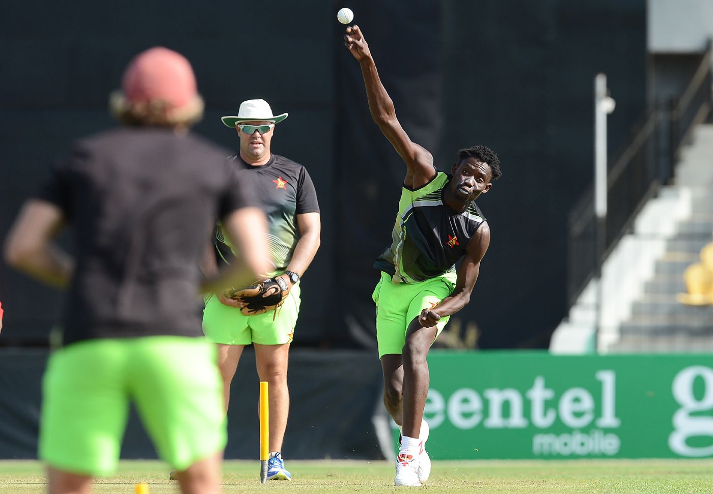 Heath Streak watches Chris Mpofu bowl during training