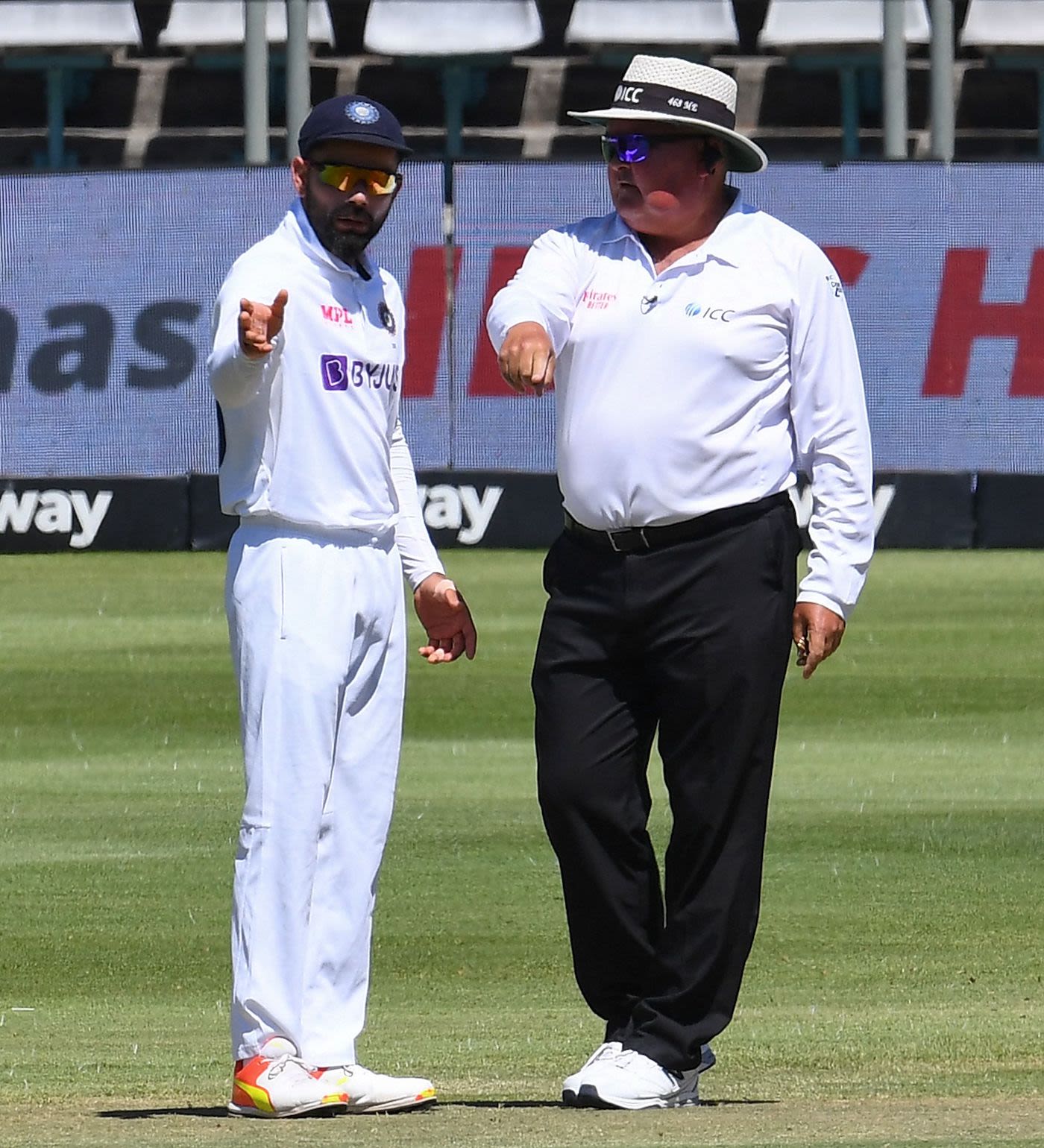 Virat Kohli chats with Marais Erasmus after the umpire had warned Mohammed Shami for stepping in the danger zone while bowling