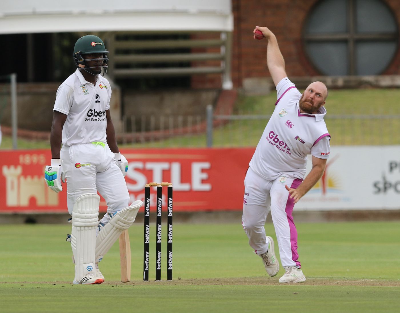 Lesiba Ngoepe watches as Shaun von Berg bowls